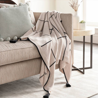 Handwoven blue and white Fleck Throw with tassels on a sofa